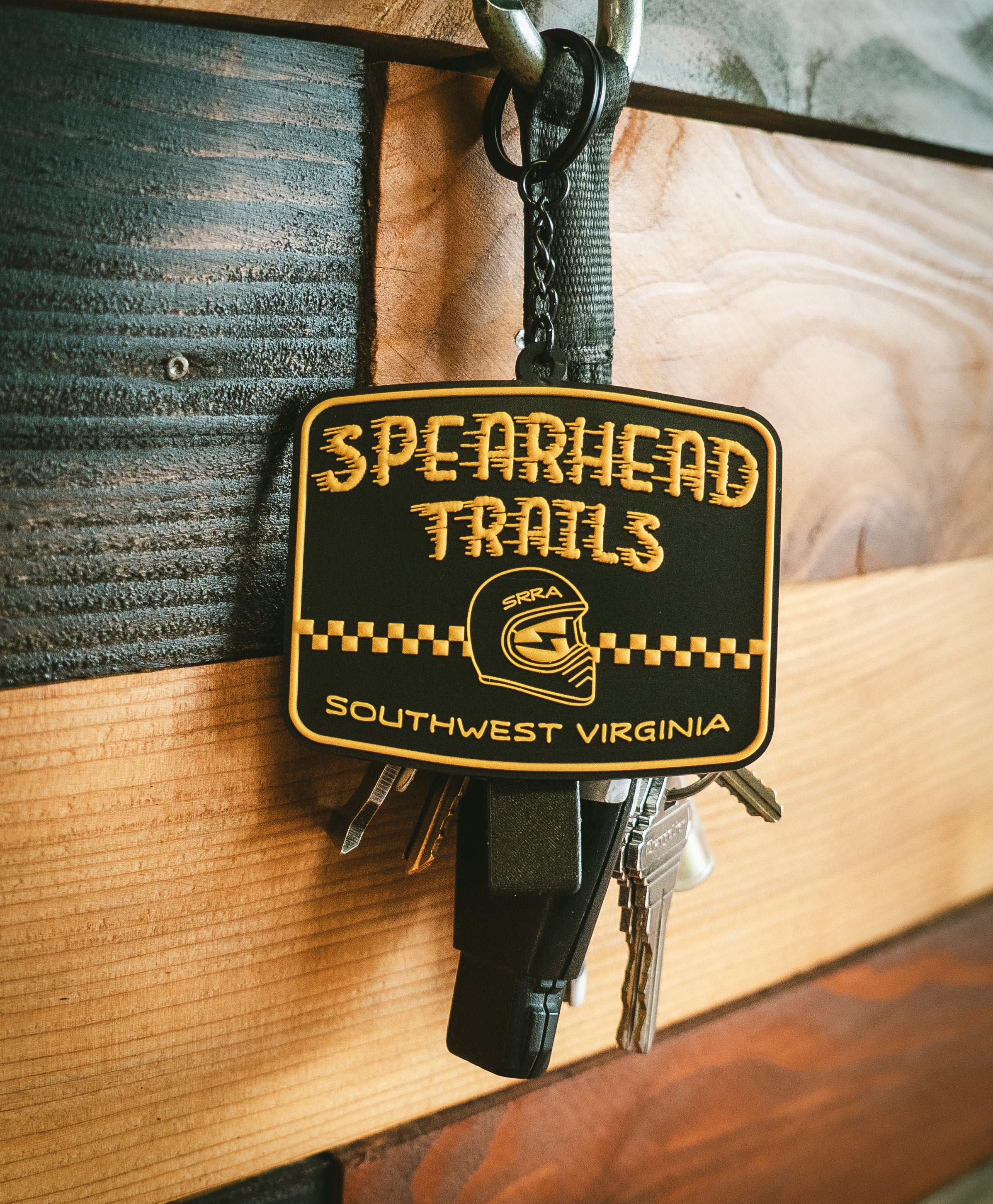 Keychain with 'Spearhead Trails' logo on a wooden surface