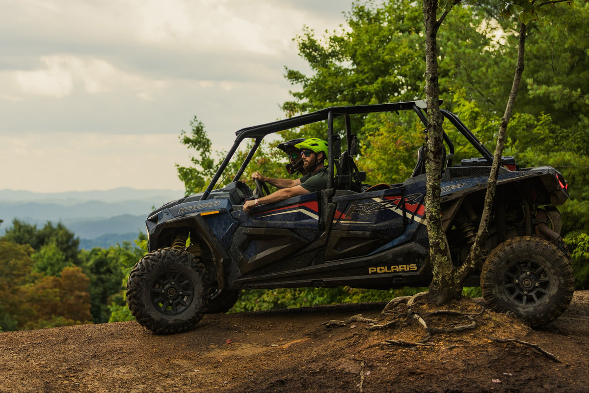 Person sitting in a Polaris vehicle on a scenic trail with trees and mountains in the background in Southwest Virginia